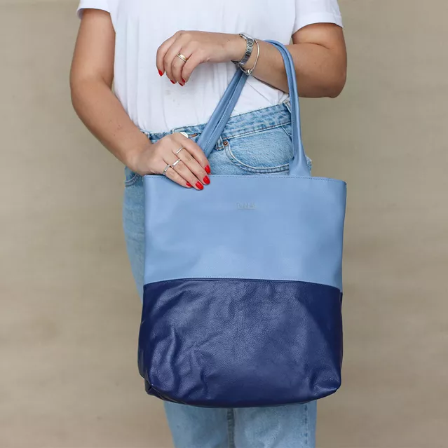 A modelo está usando Bolsa de Ombro de Couro - BICOLOR - Azul